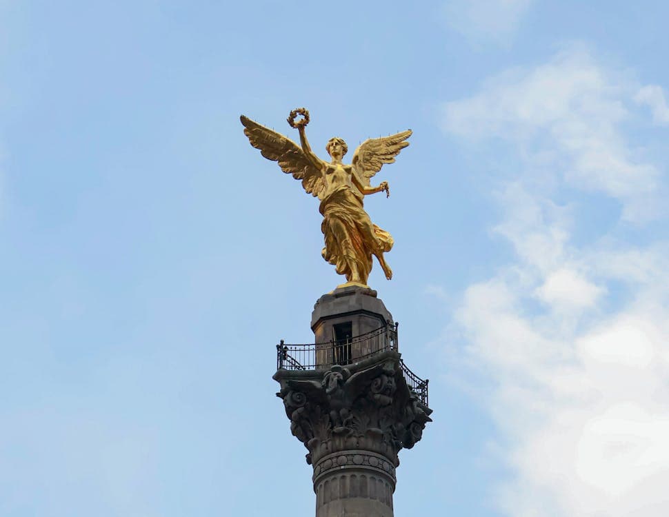 El Ángel de la Independencia rising against a blue sky over Paseo de la Reforma in Mexico City